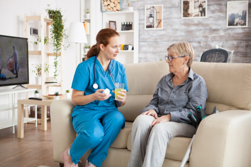 A nurse giving a lady medicine 